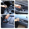 Hands are using a soft bristle detailing brush to clean and wipe down the interior surfaces of a car.
