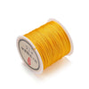 A spool of yellow 0.8mm nylon macramé cord for jewelry making with Chinese text on the label.