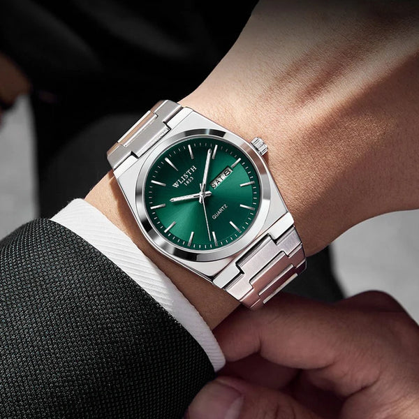 A close-up of a silver quartz watch with a green dial and rose gold accents worn on a wrist.