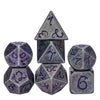 A set of seven metal polyhedral dice with a dragon font design, including a tetrahedron and a cube.