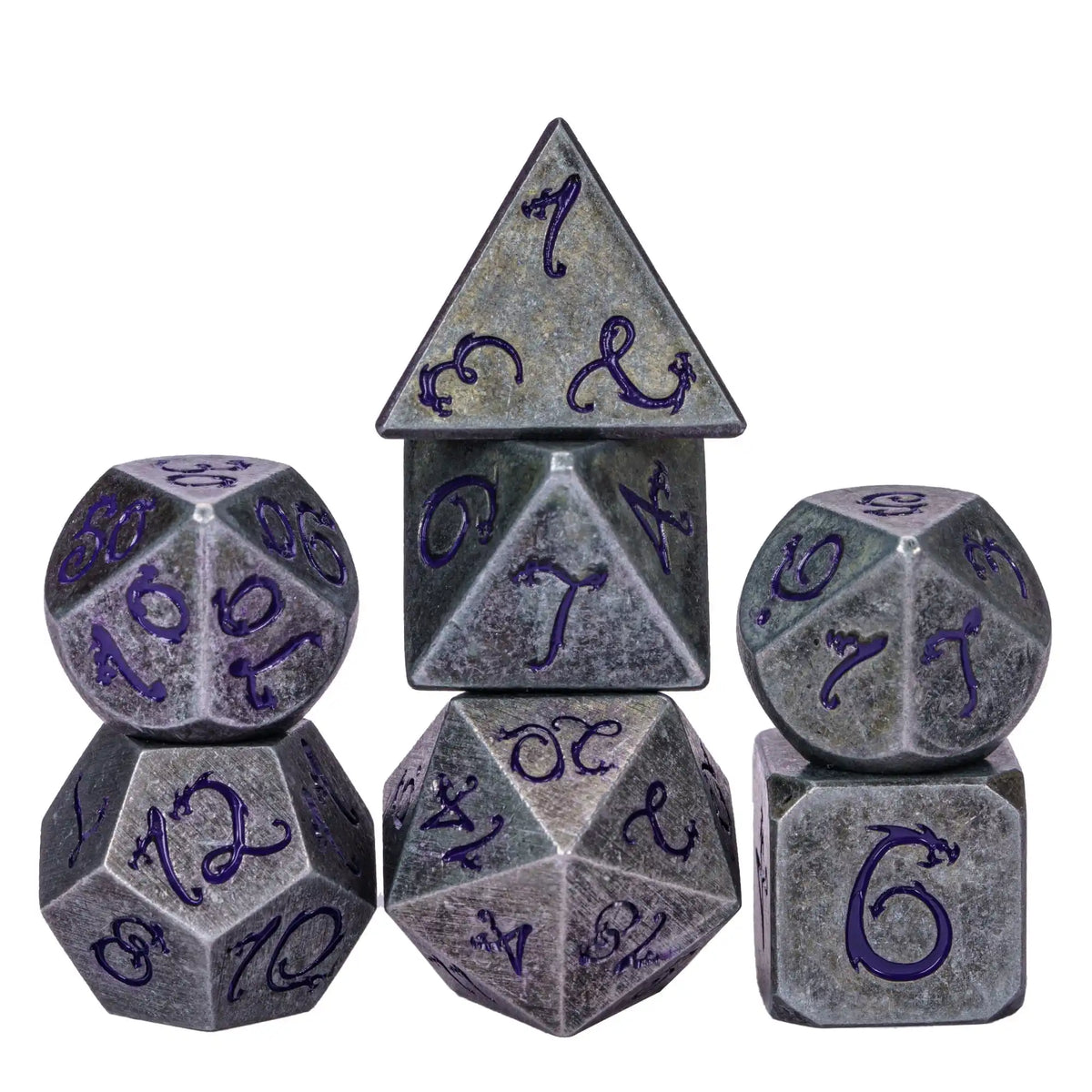 A set of seven metal polyhedral dice with a dragon font design, including a tetrahedron and a cube.