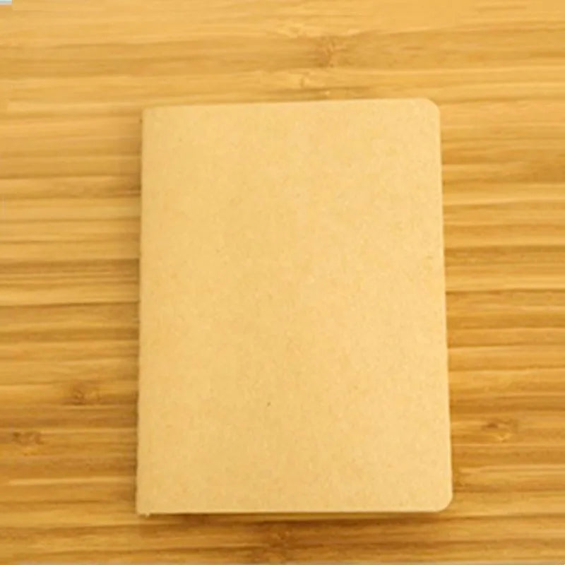 A blank A6 Kraft paper notebook lying on a wooden surface.