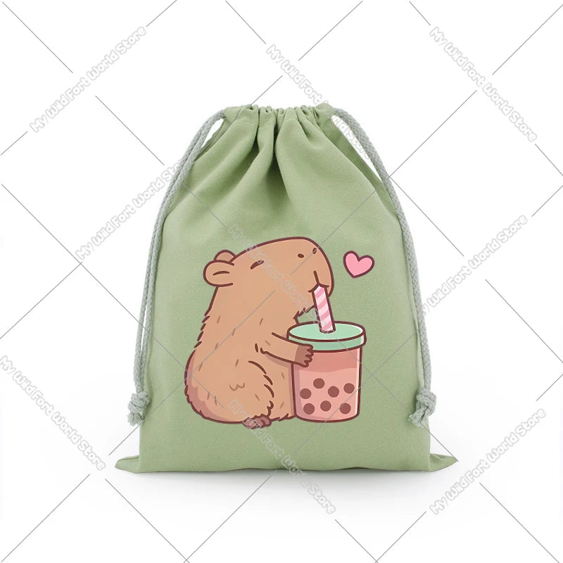 A light green drawstring storage bag featuring a cute, illustrated brown capybara holding a pink straw drink.