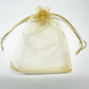 A sheer, light gold organza drawstring bag tied with a bow, used for gifts or party favors.