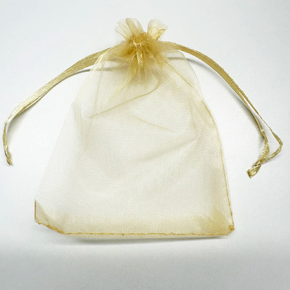 A sheer, light gold organza drawstring bag tied with a bow, used for gifts or party favors.