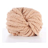 A ball of light beige chunky acrylic yarn used for knitting and crochet