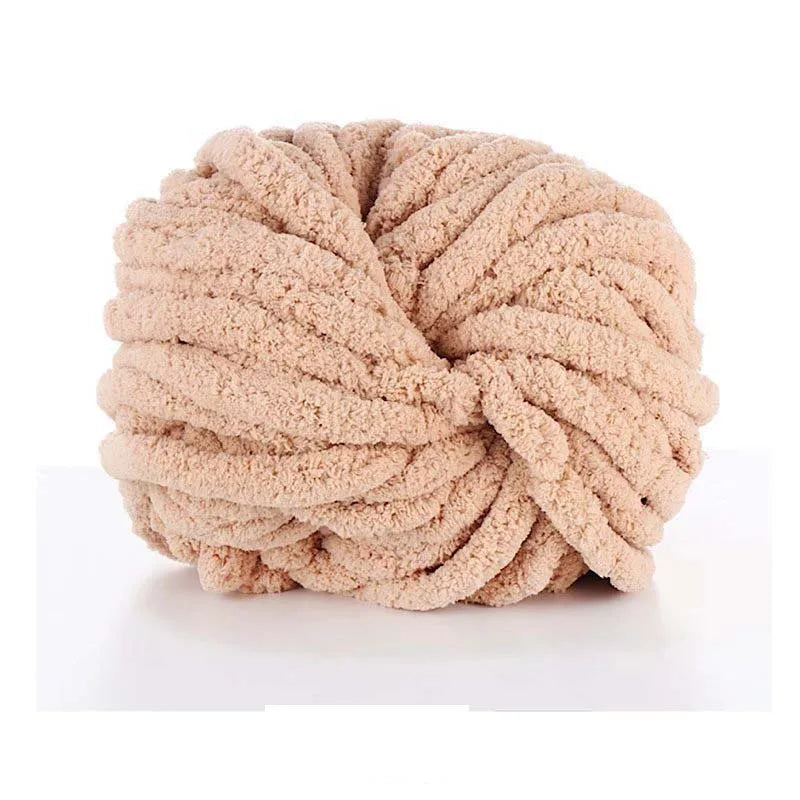 A ball of light beige chunky acrylic yarn used for knitting and crochet