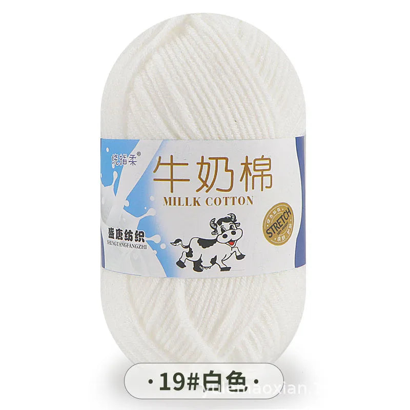 A ball of white milk cotton blend yarn labeled in Chinese and English, with a tag indicating the fiber content.