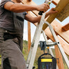 A person uses a rotating tool belt hook for drills and work gear on a wooden structure.