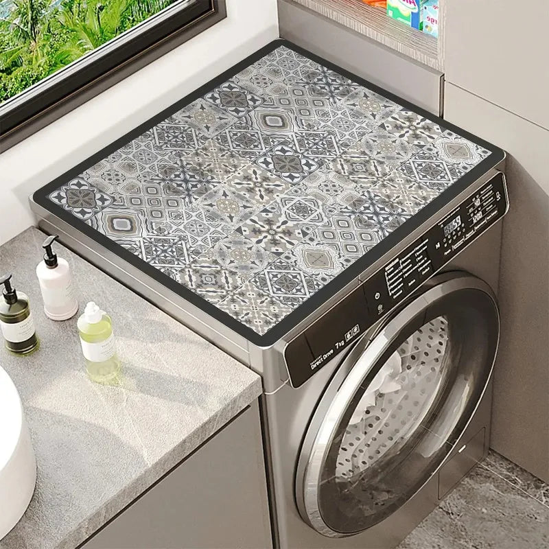 A silver washing machine with a floral print absorbent protective mat placed on the top surface.