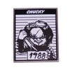 An enamel pin featuring a stylized image of Chucky the horror movie doll with the year 1988 visible.