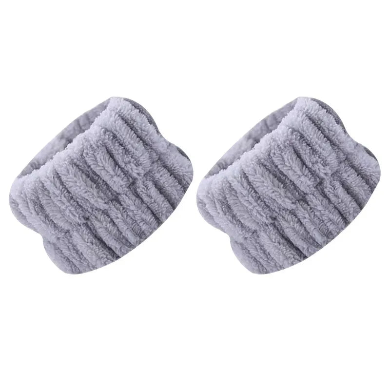 A pair of light gray absorbent microfiber wrist washing bands or face-saving cuffs.