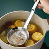 A hand is using a stainless steel fine mesh skimmer spoon to remove oil and foam from food in a pot.