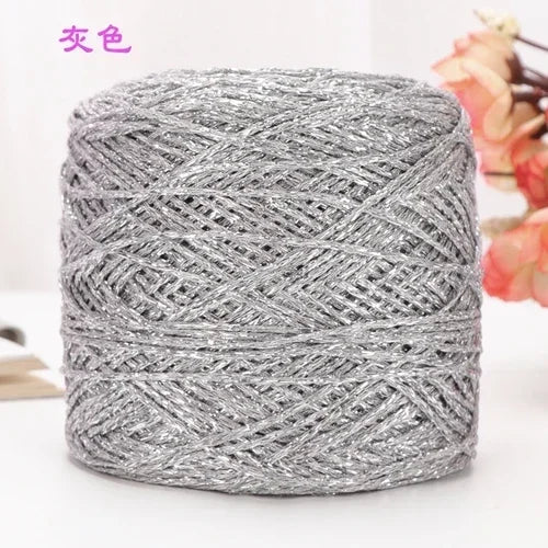 A ball of silver metallic silk crochet yarn used for knitting and macrame.