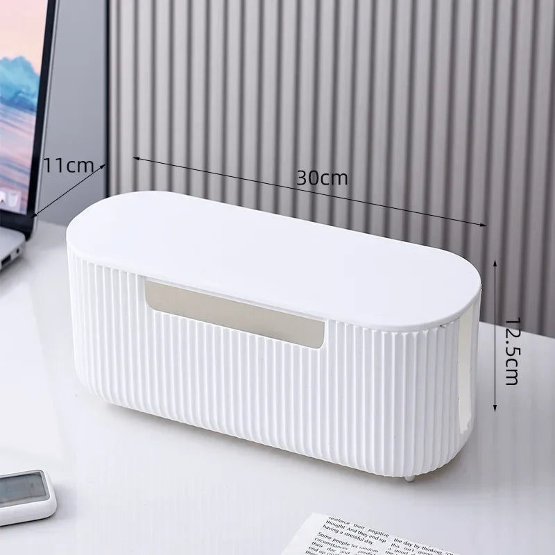 A white cable management box with a slotted opening is shown on a desk, measuring 11cm in length and 12.5cm in height.