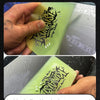 A hand is applying a clear film to a surface using a squeegee, demonstrating the film's ability to prevent water marks.