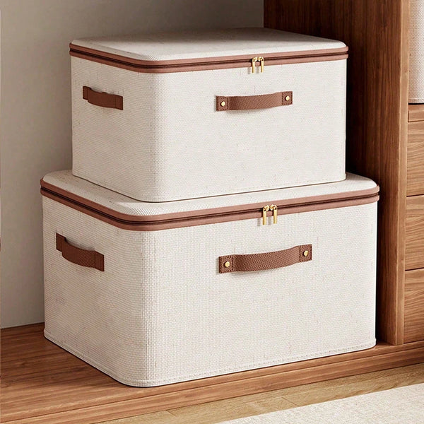 Caja organizadora plegable con cremallera de color crema y detalles en cuero marrón, sobre un suelo de madera.