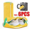 A yellow reusable shoe laundry bag with a brush and a pair of white sneakers is shown next to a washing machine.