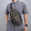 A man wearing a gray shirt carries a olive green multifunctional chest bag on his chest.