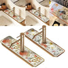 A set of floral diatomaceous earth faucet mats with modern metal faucets displayed on a wooden surface.