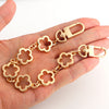 A gold-colored adjustable flower bag chain extender is shown being held in a hand.