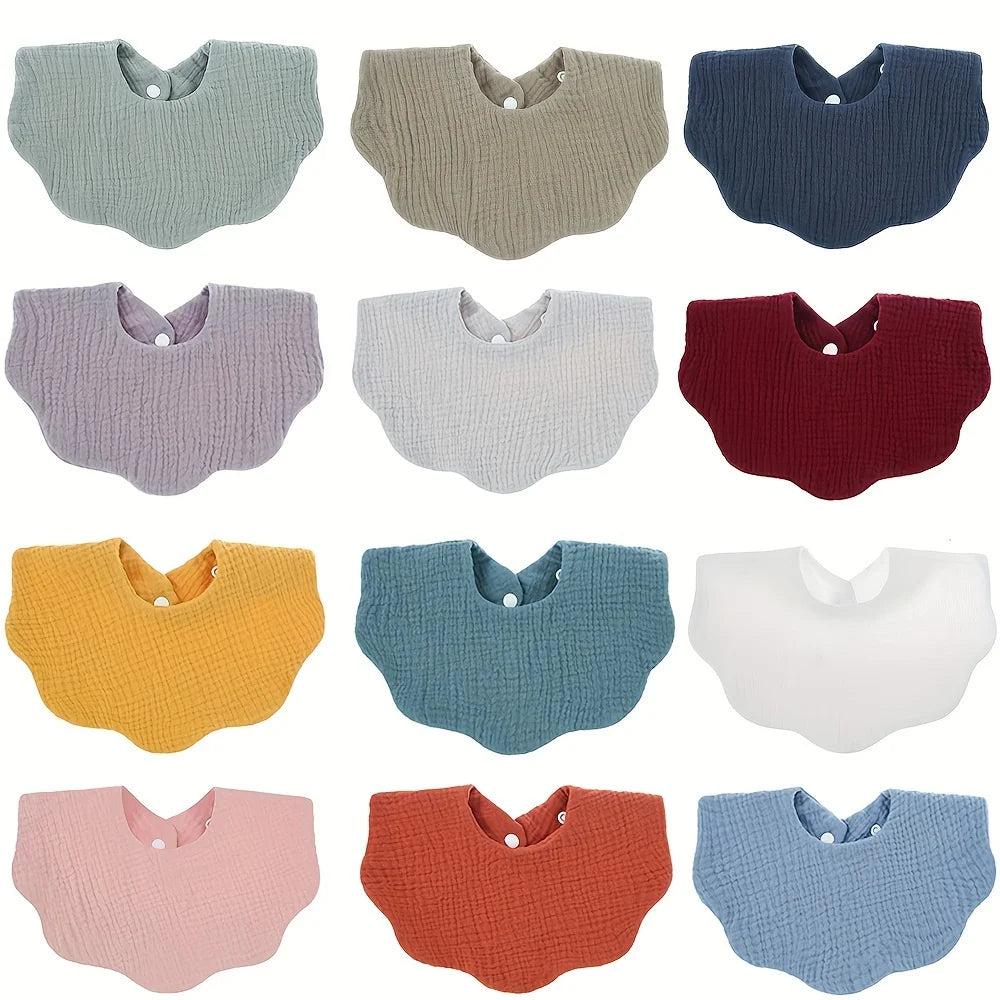 A collection of colorful soft cotton baby bibs in various colors and textures for newborns.