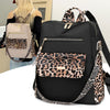 Schwarzer Mode-Reiserucksack mit Leopardenmusterakzenten und goldfarbenem Hardware, neben einer Person.
