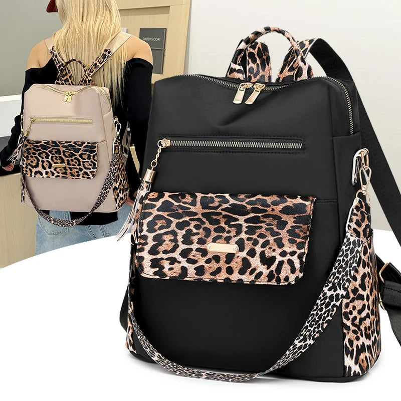 Schwarzer Mode-Reiserucksack mit Leopardenmusterakzenten und goldfarbenem Hardware, neben einer Person.