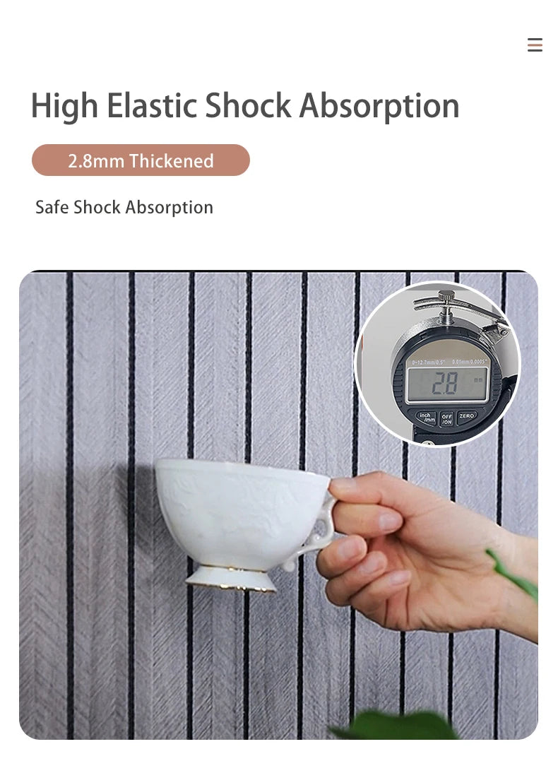 A hand holds a white ceramic cup against a gray striped wall panel, demonstrating high elastic shock absorption.