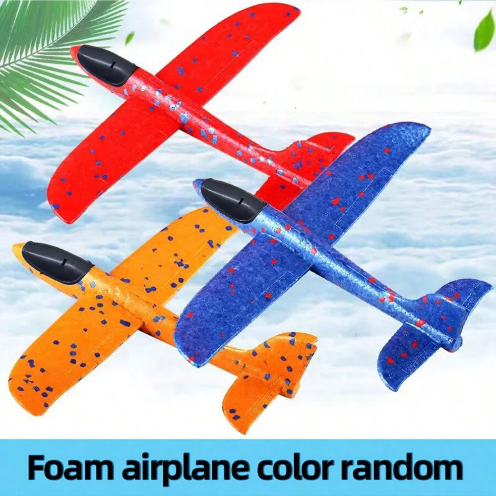 A set of foam airplane glider planes in red, blue, and orange colors flying against a snowy sky background.