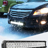 A black LED flood light bar with multiple bright bulbs is shown in front of a snowy outdoor scene.