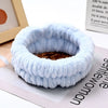 Light blue microfiber wrist sweatband and scrunchies for face washing shown on a white surface.