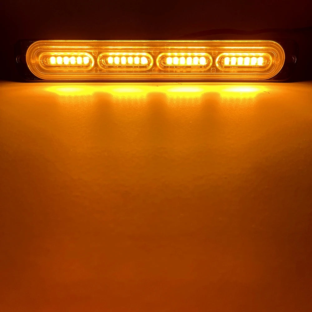 An illuminated amber strobe warning light bar mounted on a dark surface.