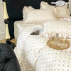 A set of three white bedding pieces featuring a black dot print, including a duvet cover and pillows.