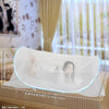 A clear instant pop-up mosquito net is shown draped over a bed, demonstrating its size and use for protection.
