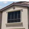 A close-up of a modern building exterior featuring a rectangular window with dark tinting and decorative trim.