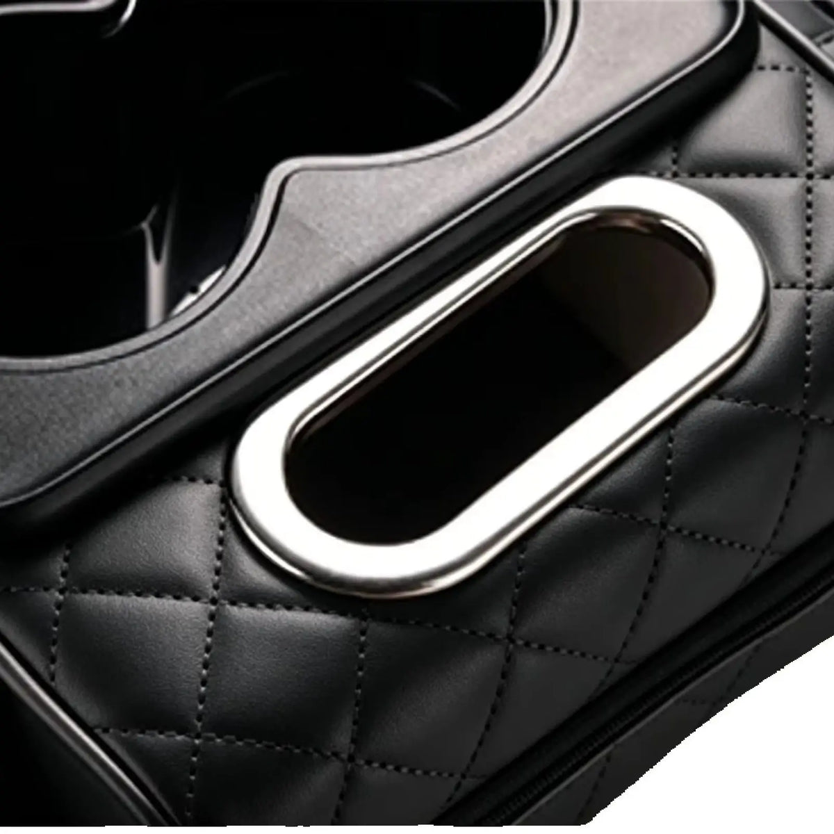 Close-up of a black quilted car center console armrest cushion featuring a silver cup holder and storage pockets.