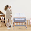 A woman is gently kissing a baby while a portable mosquito net cover for a bassinet or crib is shown on the floor.