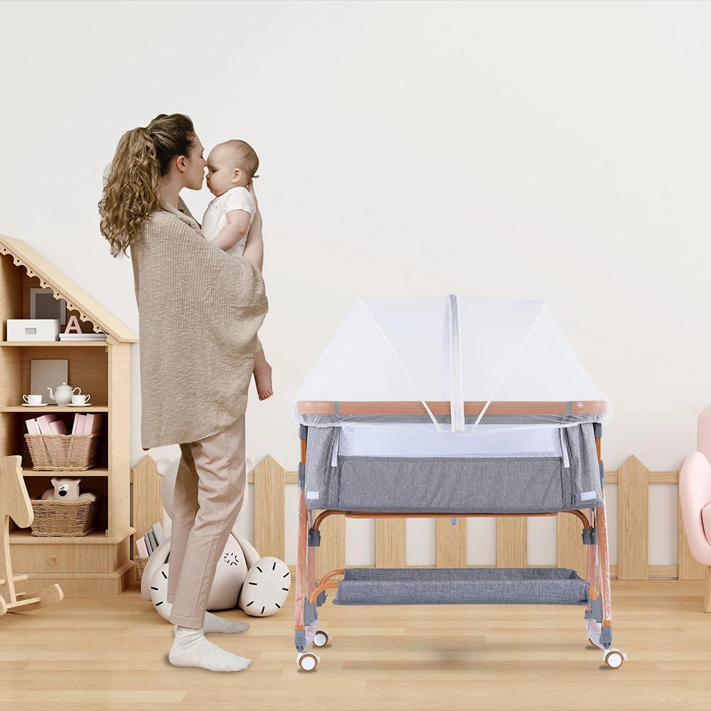 A woman is gently kissing a baby while a portable mosquito net cover for a bassinet or crib is shown on the floor.