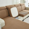 A beige Jacquard stretch sofa slipcover with a white back and light wood accents.