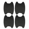 A set of four black carbon fiber protective covers for car door handles.