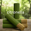 A stack of green citronella incense sticks, some lying horizontally on a wooden surface.
