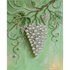 A painting featuring a delicate green branch adorned with white pearls and leaves on a light green background.