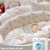 A set of pink duvet covers and pillows with a tiny bow print displayed on a bed.