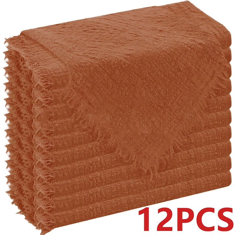A stack of six rust-colored, raw-edge polyester cloth napkins.