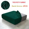 Dark green velvet fabric sofa cover in a draped style shown on a light wooden floor.