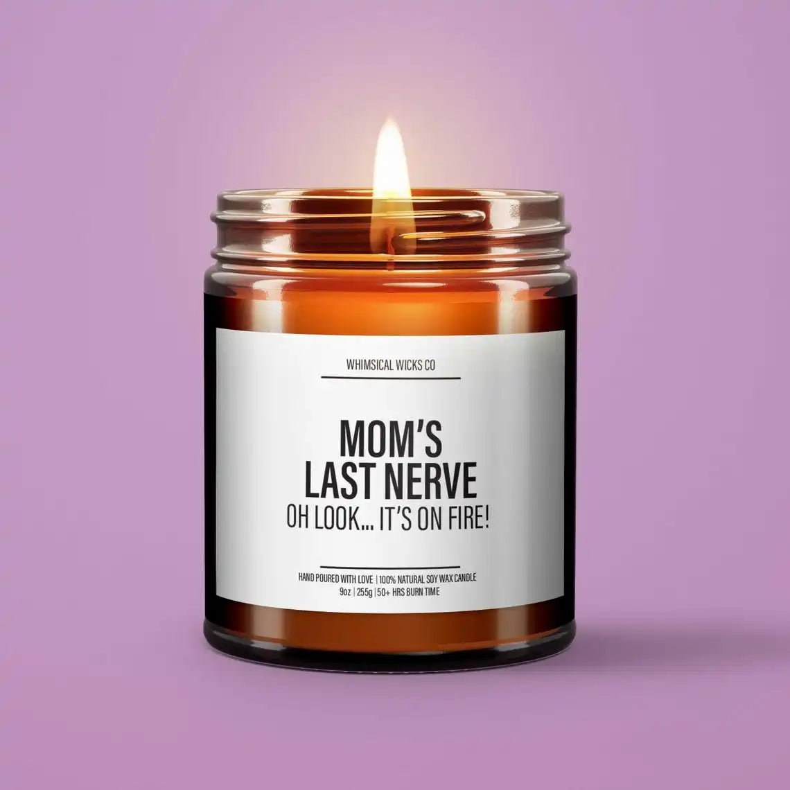 A glass jar candle with a lit wick and a glowing flame, set against a purple background.