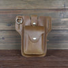 A brown genuine leather waist bag with a flap and buckle is displayed on a dark wooden surface.