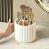 A white cylindrical organizer holding various makeup brushes and tools, shown from the side.