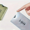 A hand is placing an RFID protection card sleeve onto a plastic card.